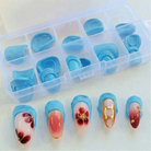 Set of blue nail art designs in a clear plastic case on a white background