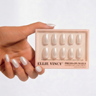 Hand holding a box of Ellie Vincy press-on nails against a white background